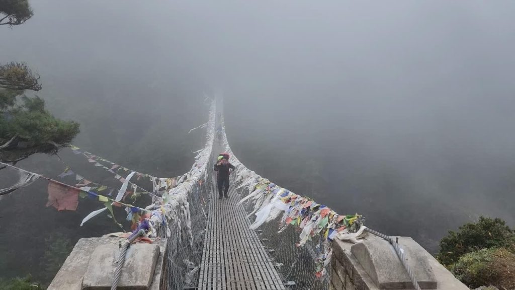 Crossing the Hillary Suspension Bridge on a cloudy, rainy day during the monsoon Everest Base Camp Trek.