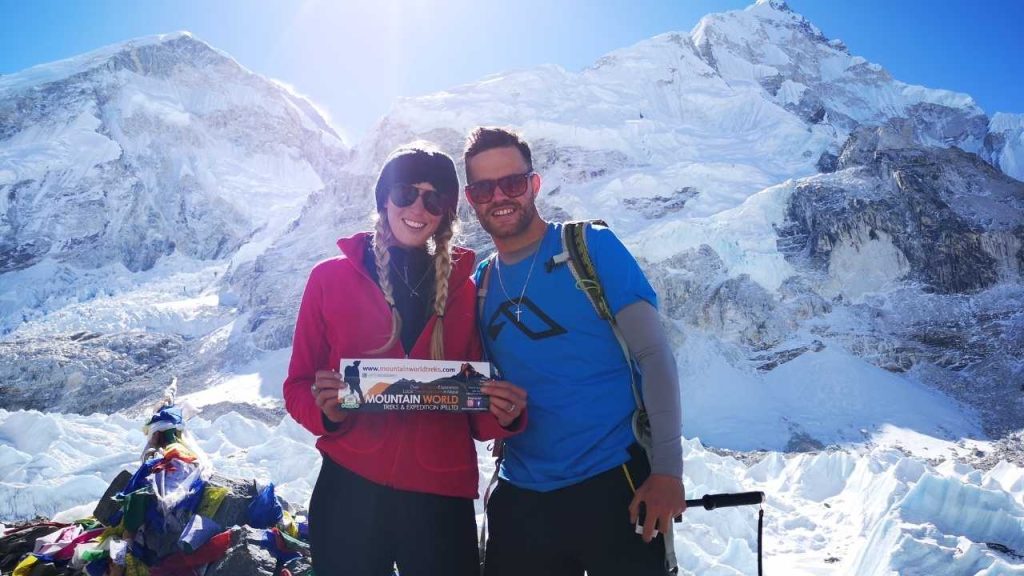 Trekkers at Everest Base Camp holding a Mountain World Treks sign